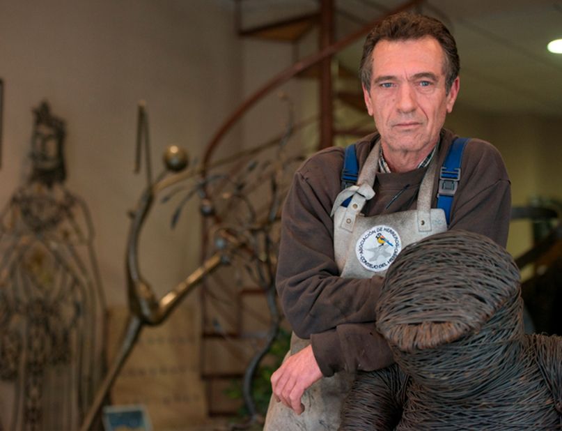 Vicente Gragera Maestro Artesano posando con una de sus esculturas de forja